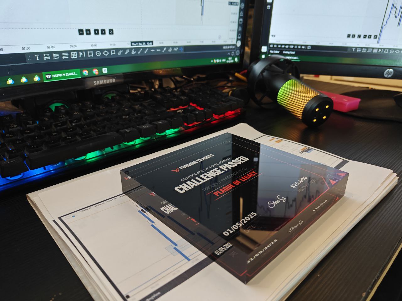 Computer setup with dual monitors, keyboard, mouse, and an acrylic plaque on a desk.