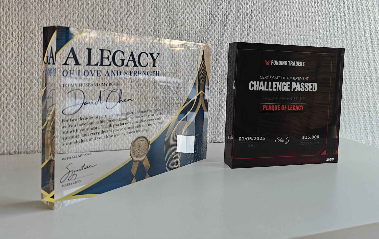 Two awards or certificates on a white surface with a neutral background