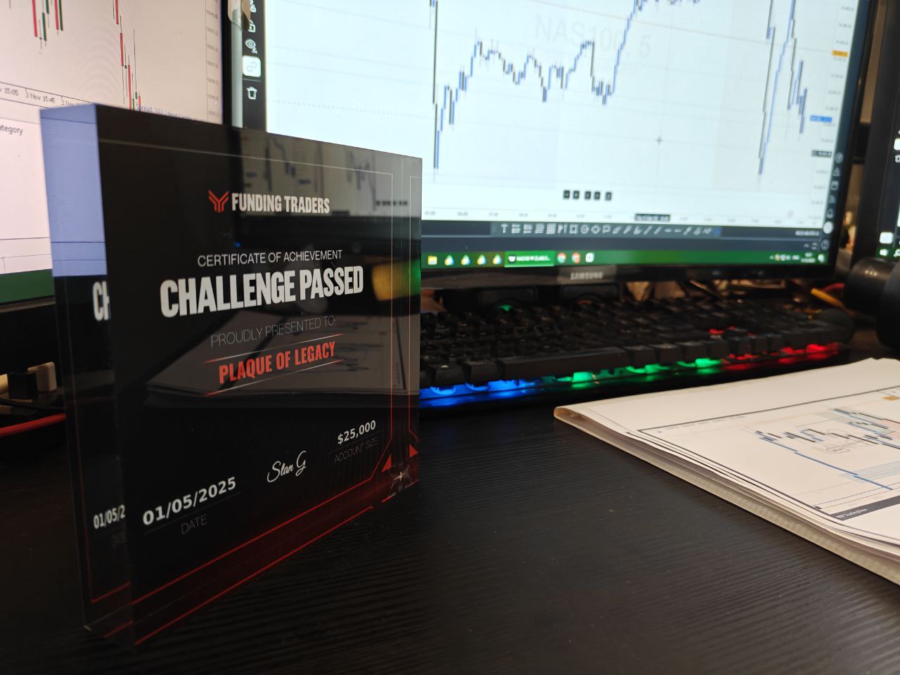 Achievement certificate for 'Challenge Passed' displayed on a desk with a computer monitor in the background.